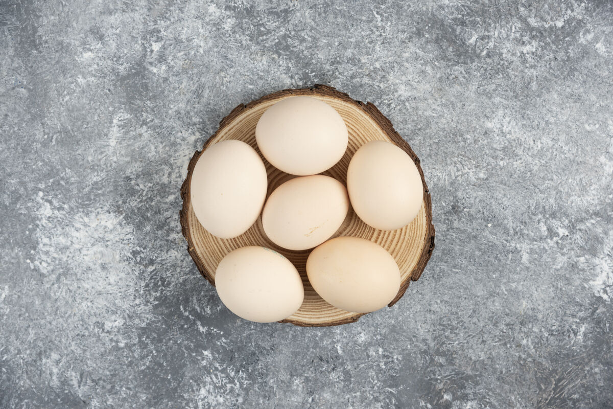 母鸡一堆新鲜的鸡蛋放在木头上蛋壳生的烹饪