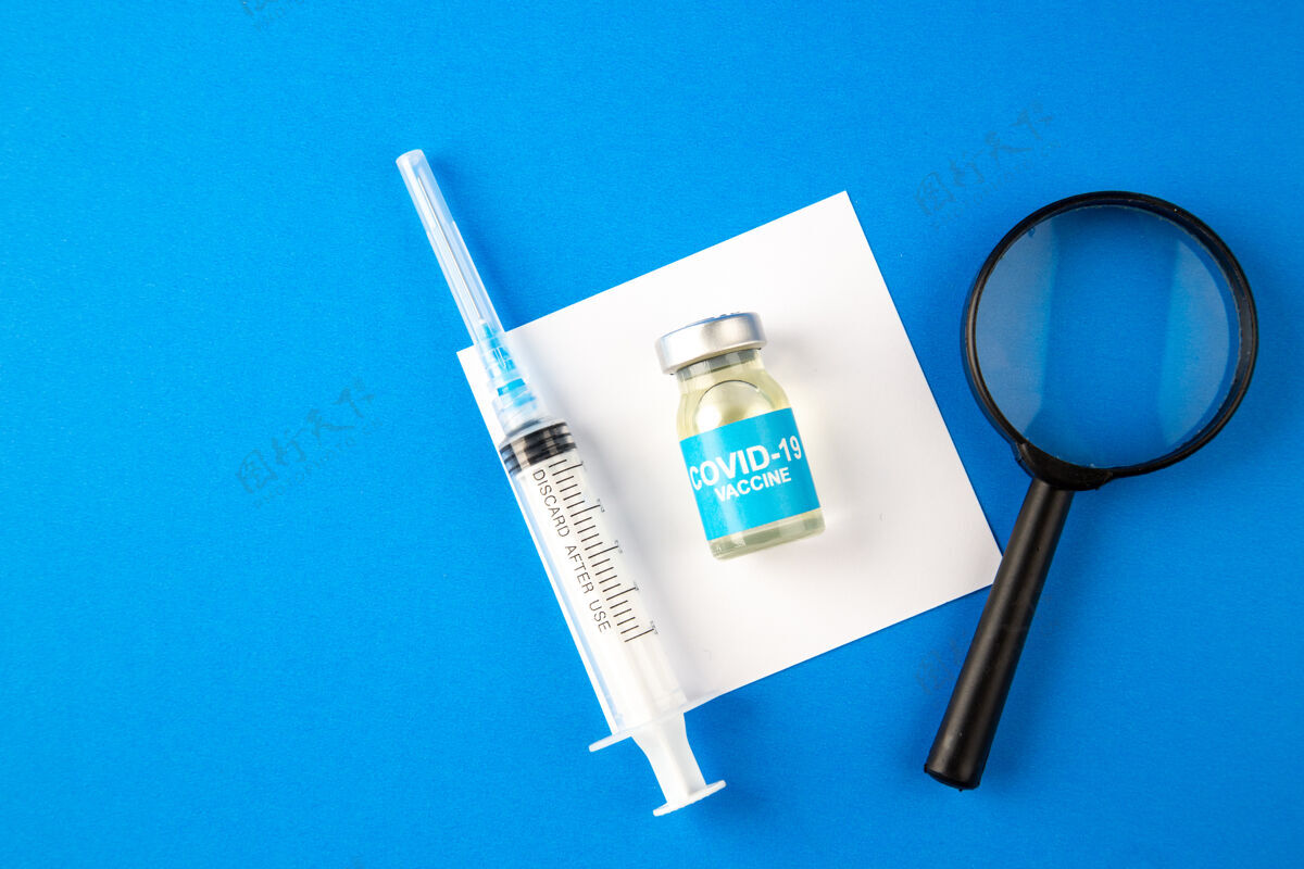 注射器俯视图带放大镜的疫苗和蓝色背景上的注射医院健康科维-实验室大流行病毒药物仪器钳子放大镜