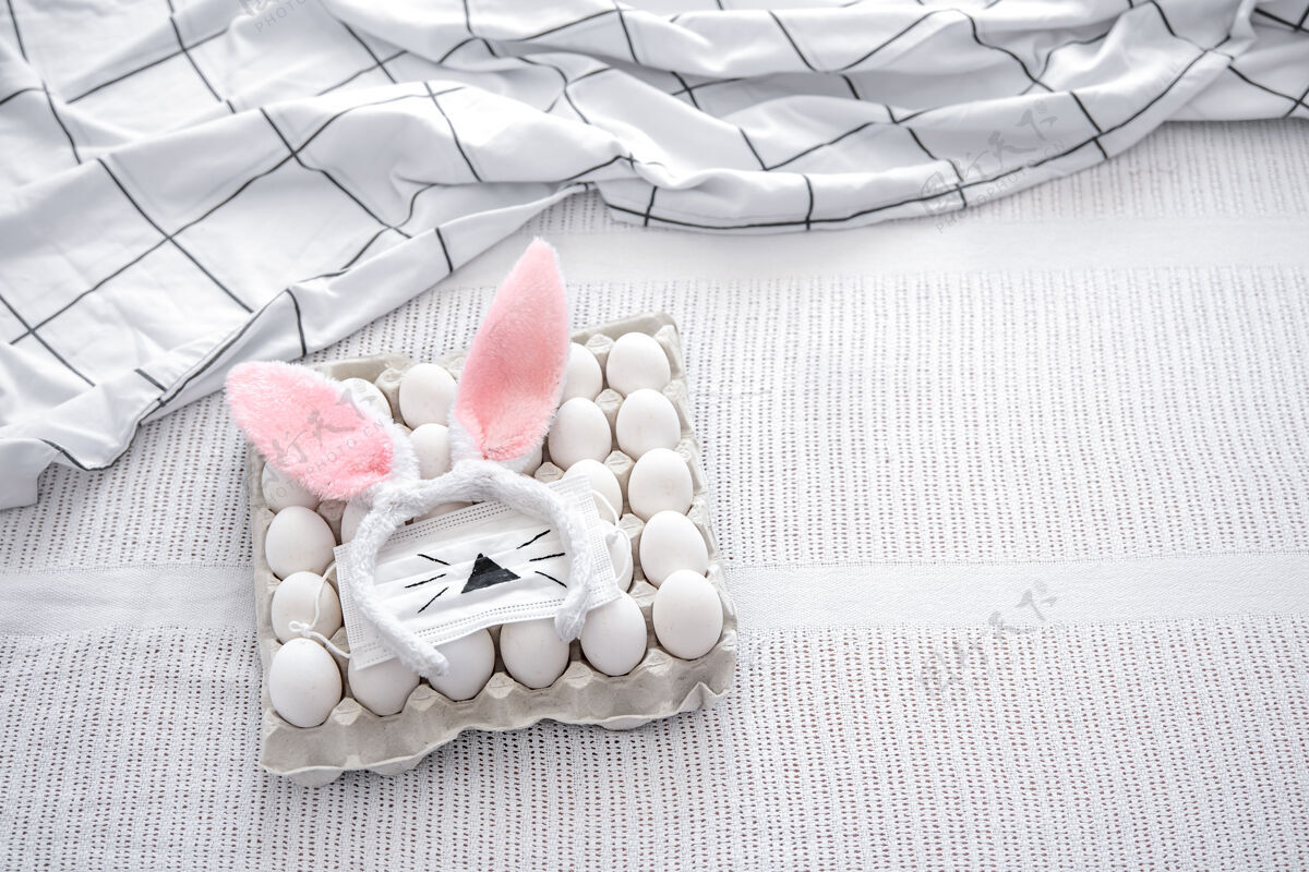 鸡蛋复活节静物与一盘彩蛋 装饰复活节兔子耳朵和一个彩绘面具检疫复活节兔子托盘