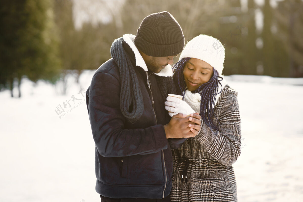 雪人们走在外面冬天非洲夫妇喝着咖啡白色成人感情