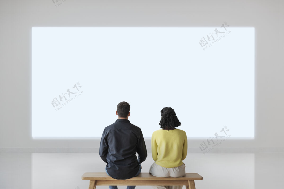 专注夫妇在看空白墙后视图娱乐长凳抬头
