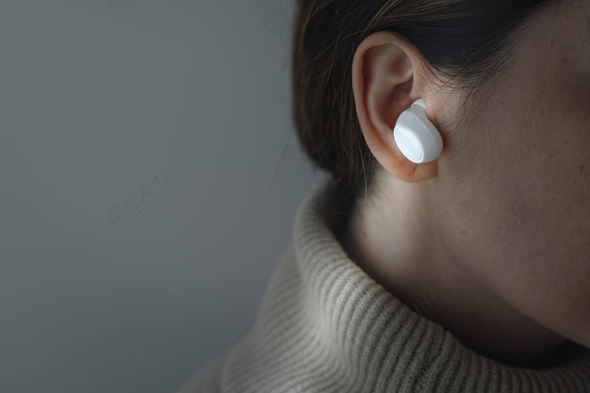 耳塞戴着白色无线耳塞的女人数字设备耳机耳朵
