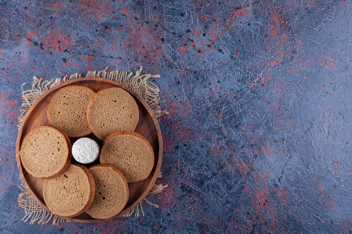 面团把切片的面包和面粉放在木板上 放在布上 放在蓝色的上面风味面包皮糕点
