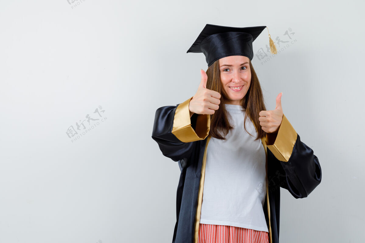 表演一个穿着休闲服 穿着制服 看起来很快乐的女毕业生竖起了大拇指正视图成就大学单身