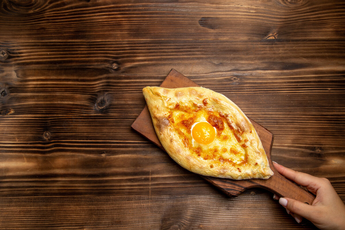 生的顶视图新鲜的烤面包和煮熟的鸡蛋放在木制桌子上面包面团食物早餐鸡蛋午餐营养品烹饪