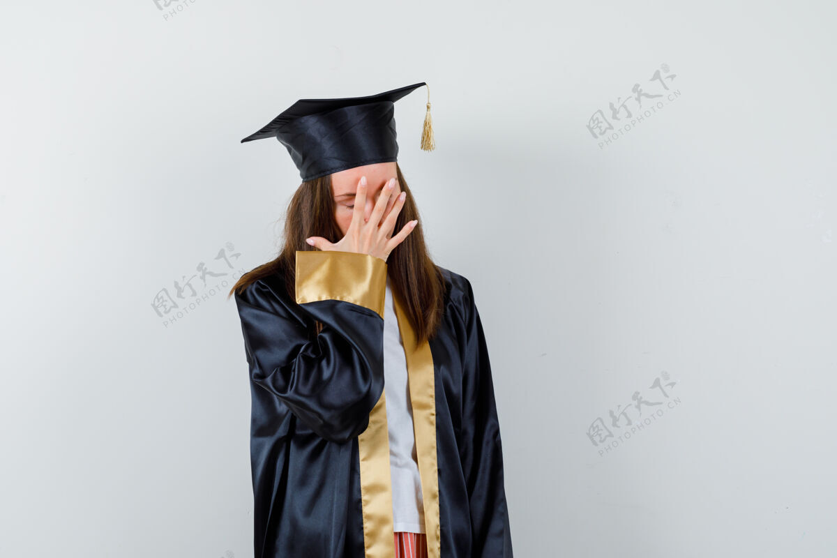 亚洲人年轻的女毕业生穿着学院服 手拉着手 脸上带着恼火的神情 前视着完美魅力漂亮