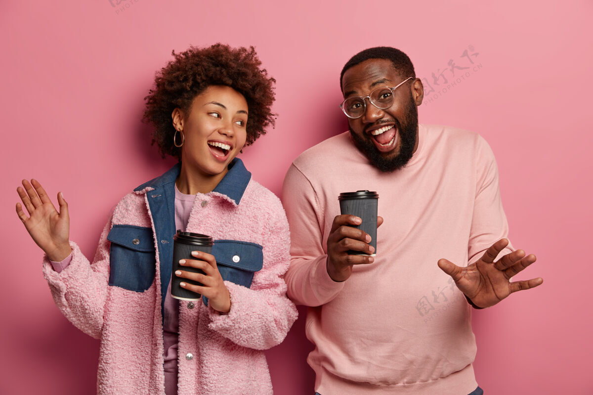 男性积极向上的美国黑人夫妇在一起开心跳舞 喝一次性杯子里的咖啡因饮料 穿休闲服牙关蜡笔非洲