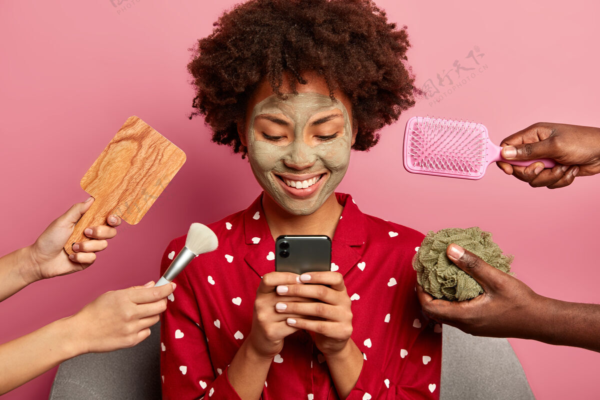 美国人快乐女人准备约会 和男朋友留言 为拥有完美的容貌做美容程序 穿睡衣手机刷子在线