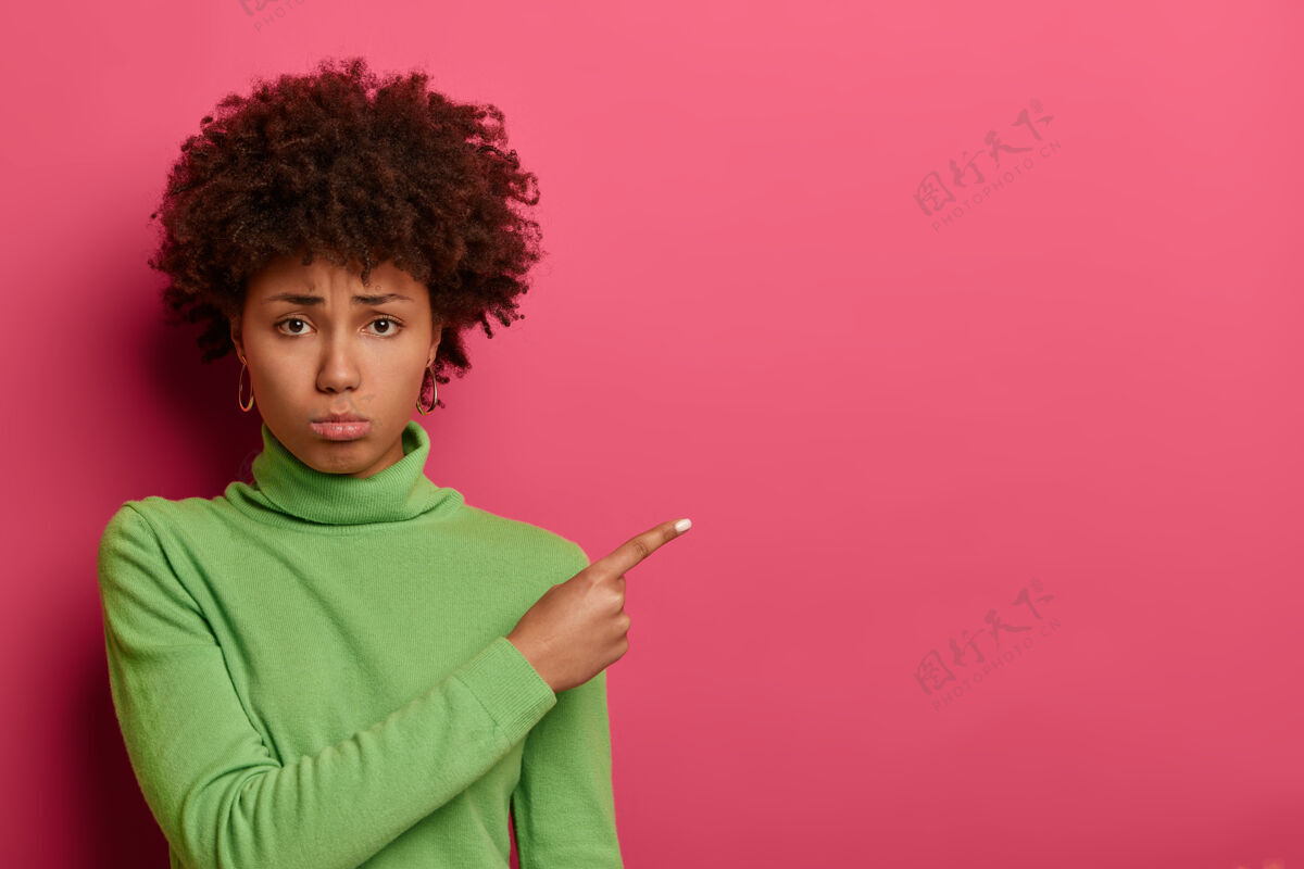 沮丧不开心不满意的女人指着空白处 捂着嘴失望地讨教 很不高兴 不相信好运女性不高兴皱眉