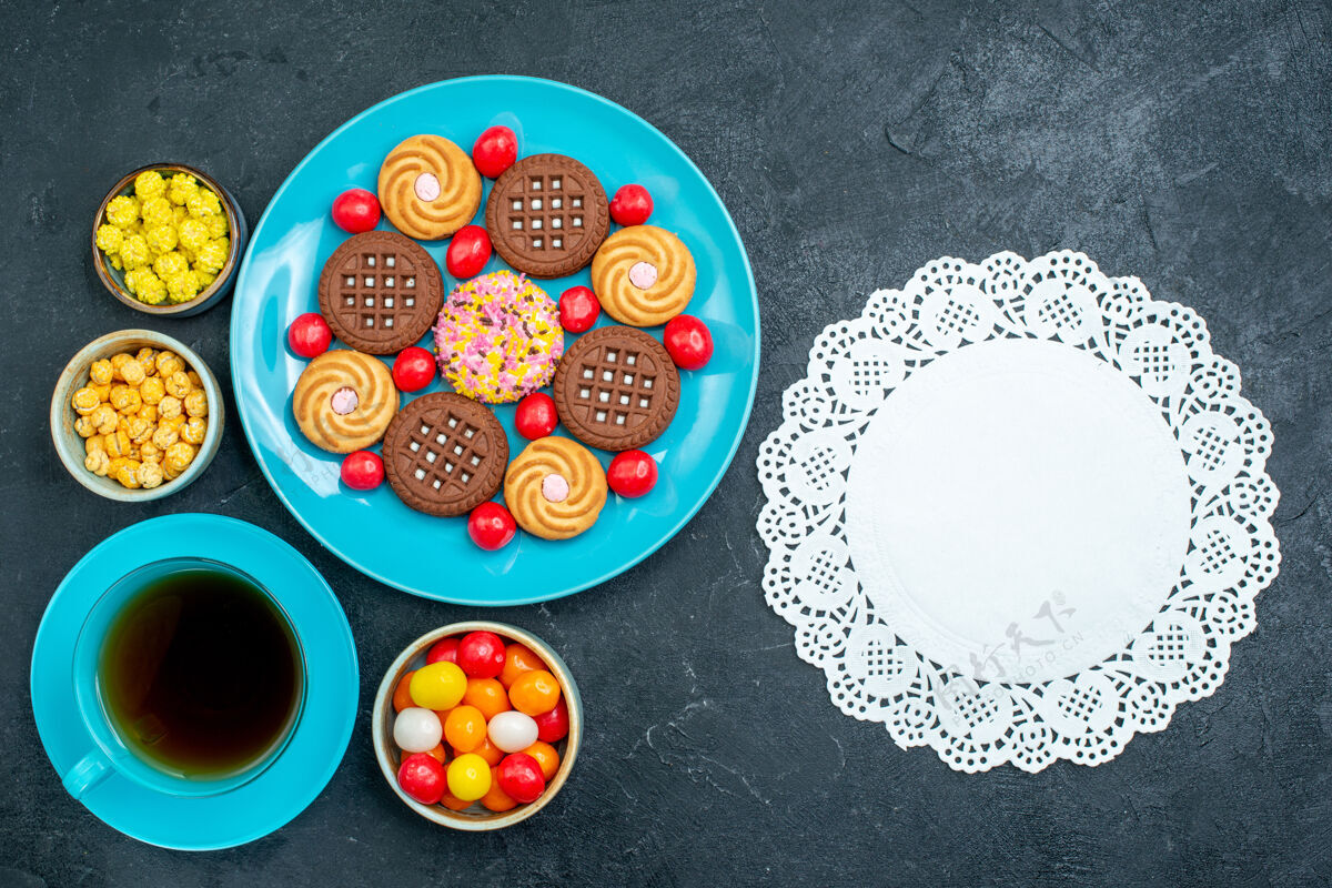 不同顶视图不同的糖饼干与糖果和茶杯灰地板糖果糖甜茶饼干饼干圆形柜台杯子