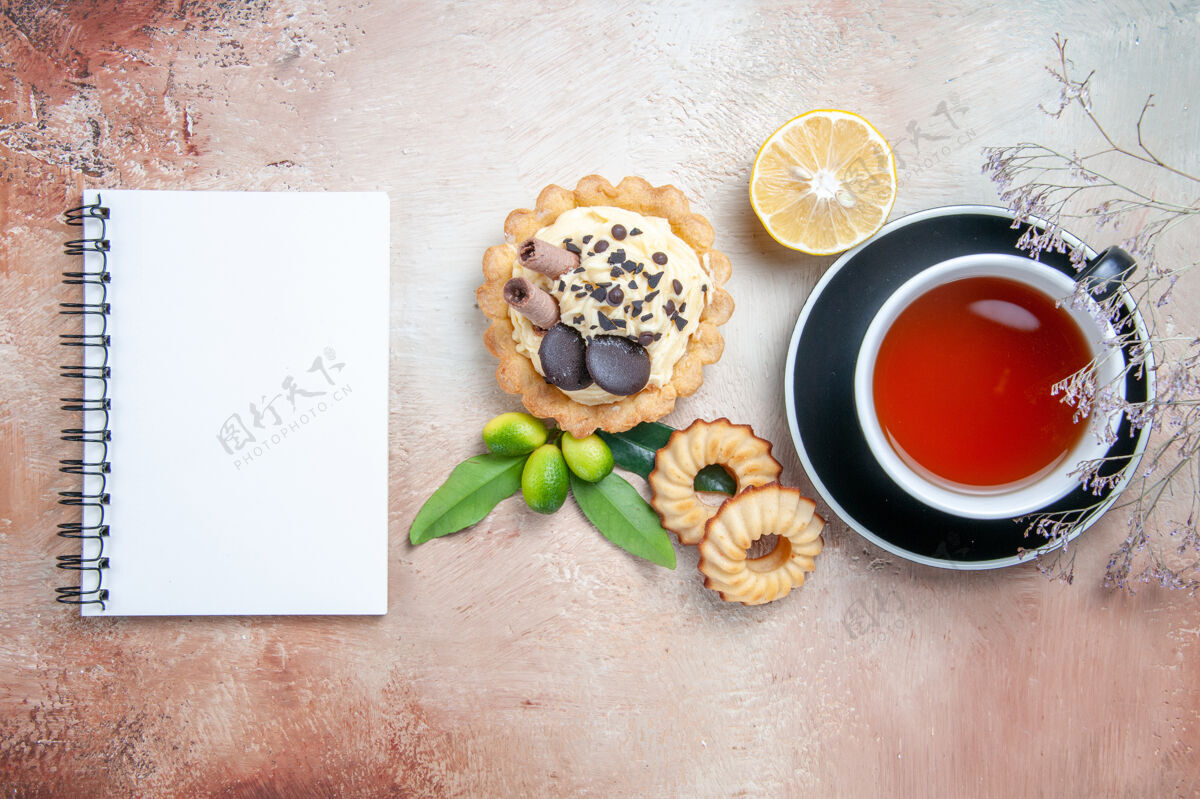 茶杯顶部特写镜头一杯茶蛋糕饼干一杯茶柑橘类水果白色笔记本身体顶部花