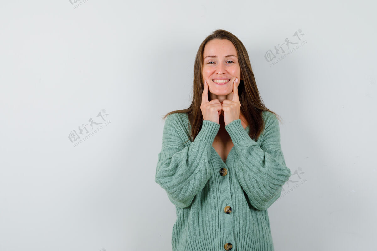 女孩年轻女士穿着羊毛开衫 手指贴在脸颊上 看上去很高兴的正面照片羊毛女人保持