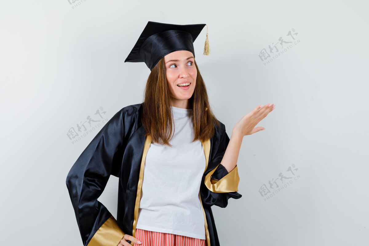 妇女女毕业生身着校服 便装示人 一边抬头 一边欢快地看 前视女孩成人证书