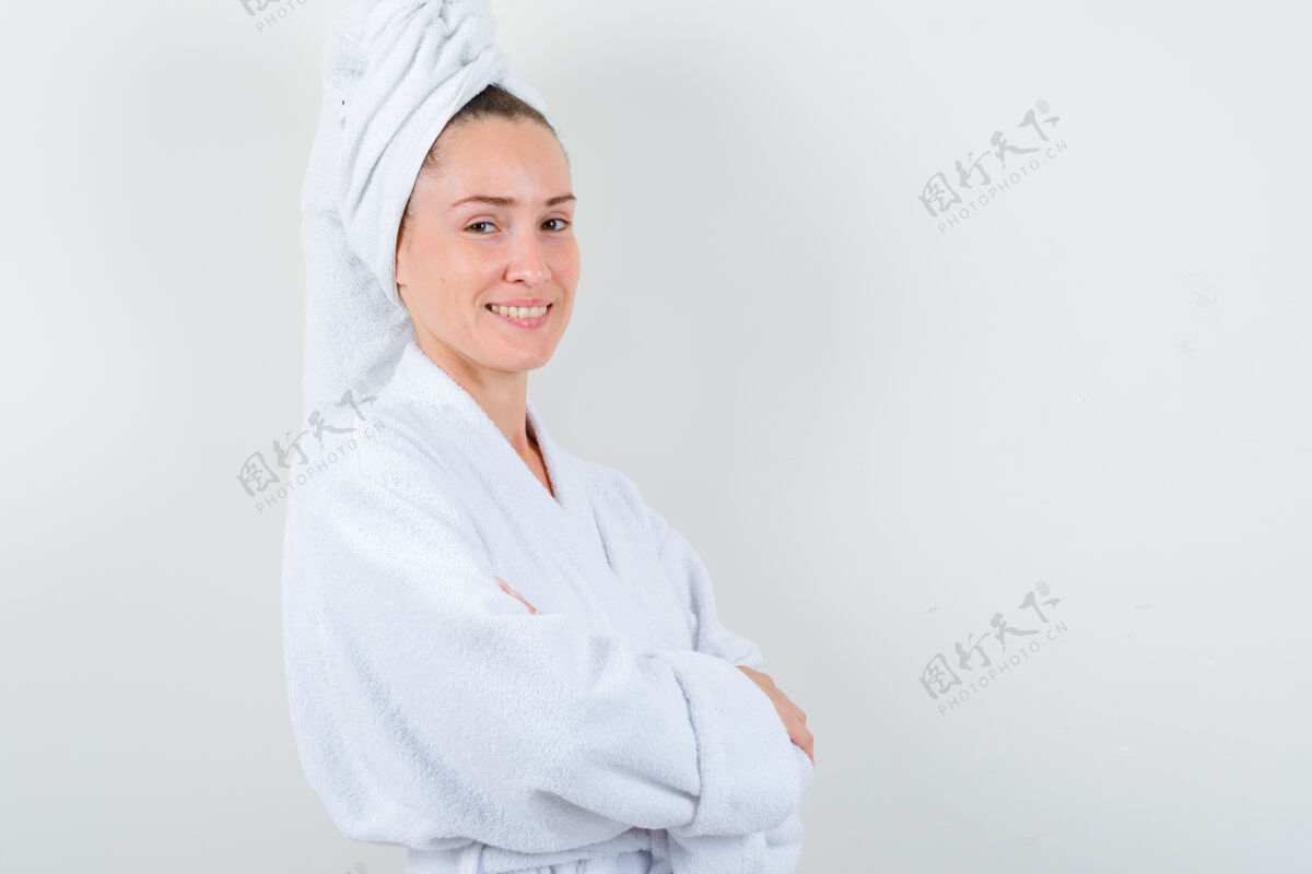 健康身穿白色浴袍的年轻女士 双手交叉站在毛巾上 看上去很自信 正面照手臂毛巾健康