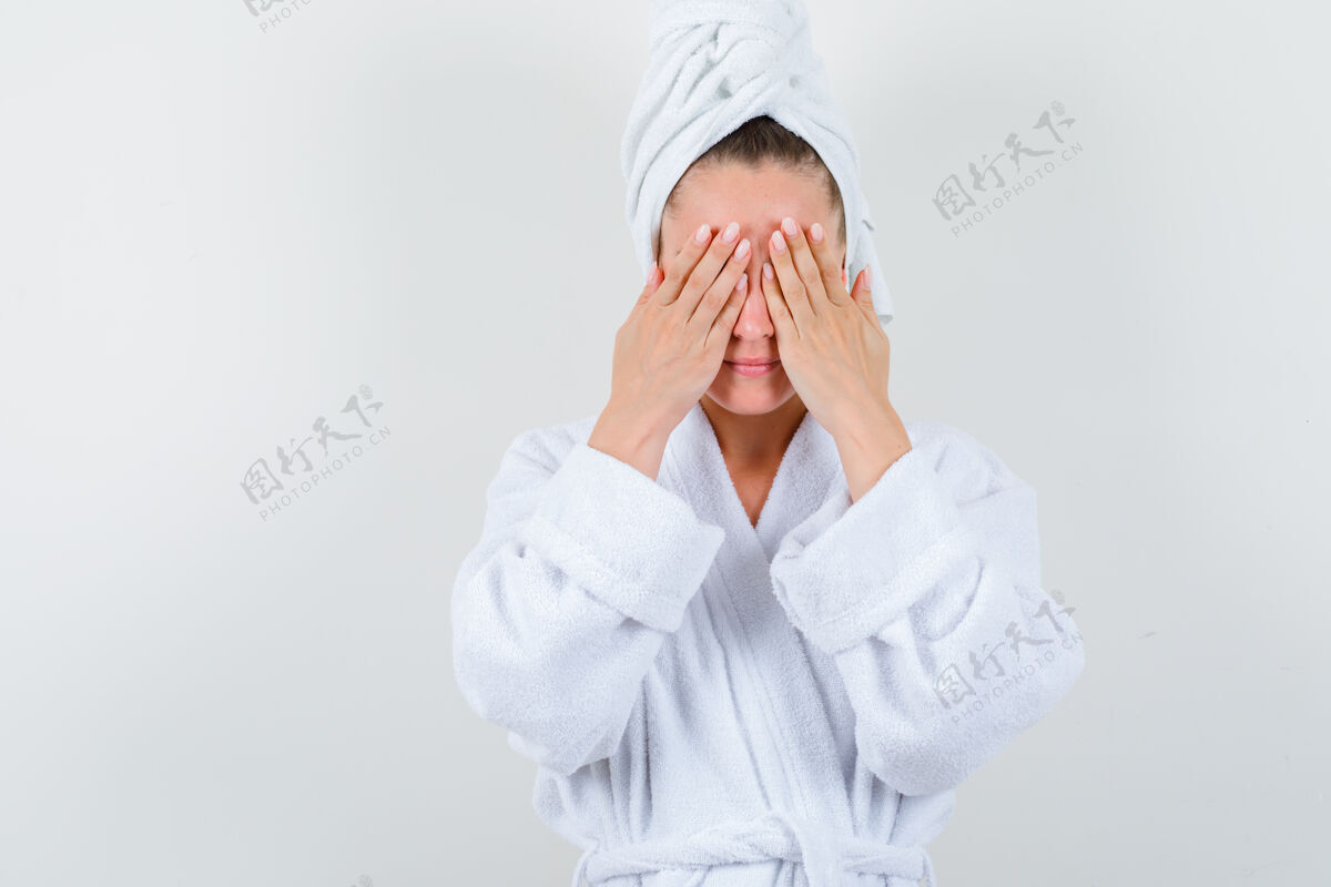 女性穿着白色浴袍的年轻女士 用毛巾捂住眼睛 满脸怨恨 前视女士自然微笑