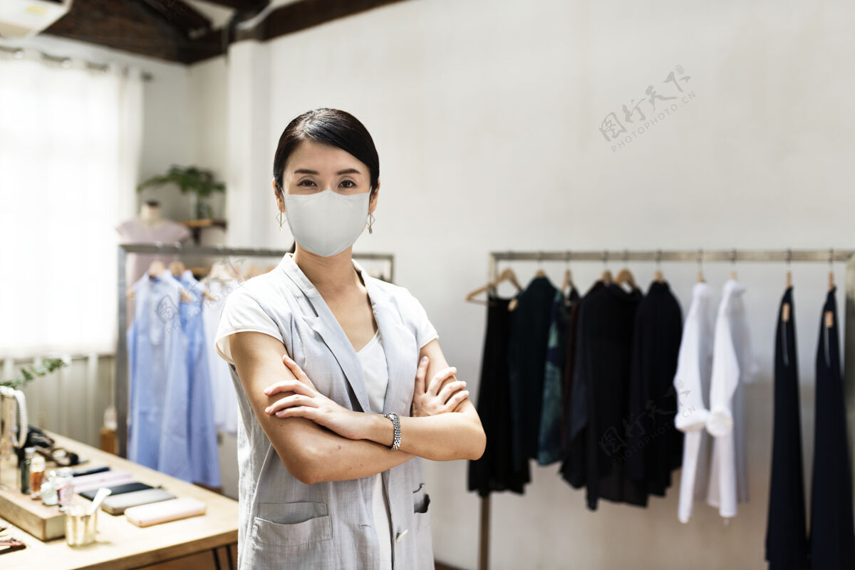 防护零售业的新常态 戴着Covid19面具的员工日本人女老板升华