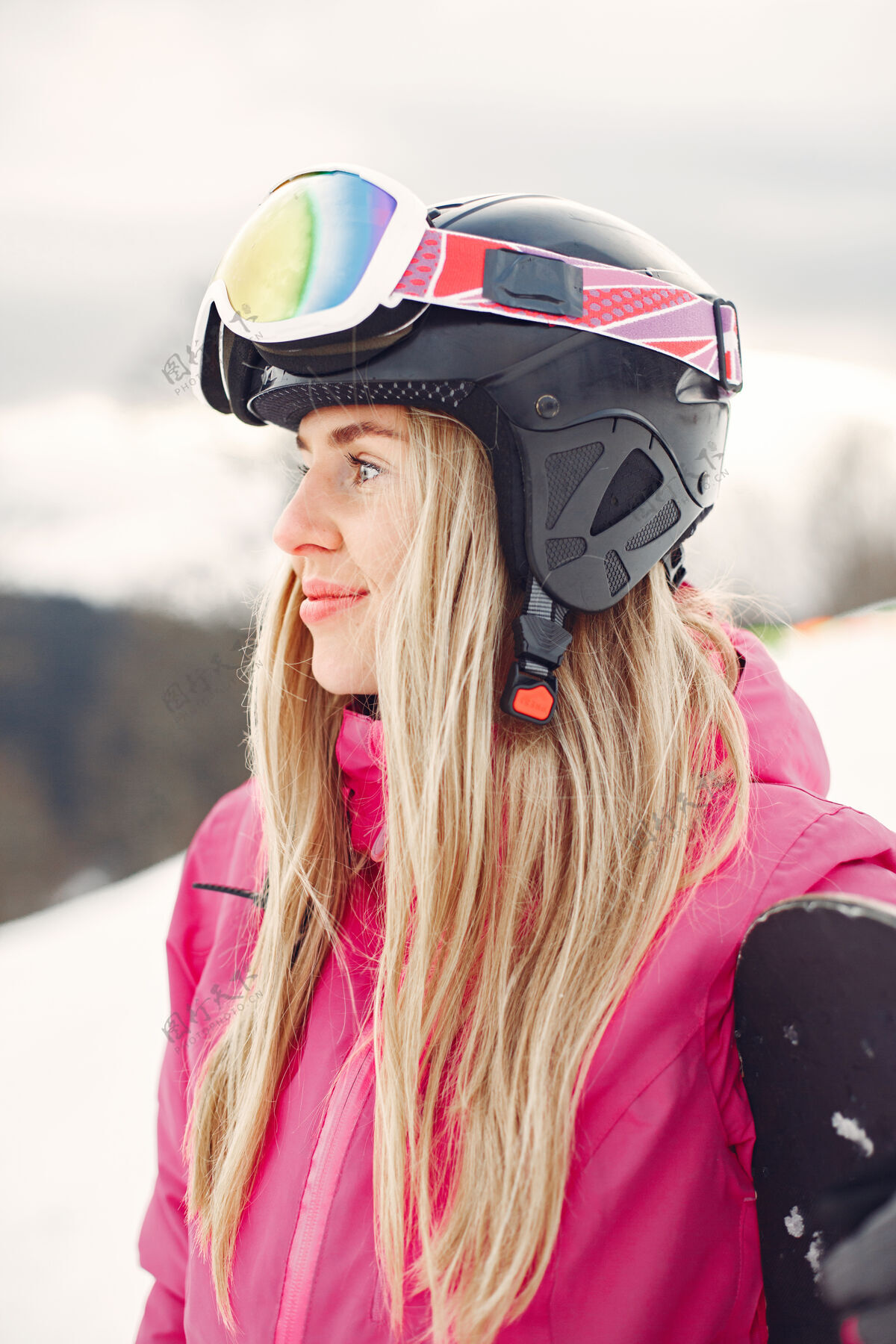 雪穿着滑雪板套装的女人在山上手拿滑雪板的运动员在地平线上关于运动的概念山护目镜滑雪板