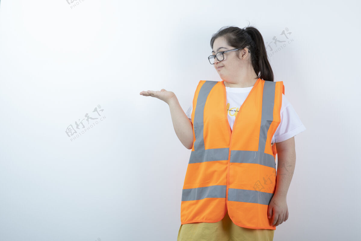 唐氏综合症戴着眼镜的年轻女工程师在白墙上拿着空地工程师残疾眼镜