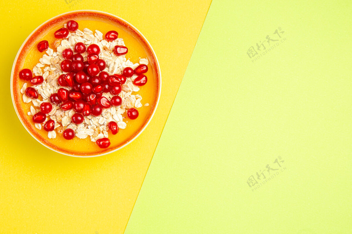 碗燕麦片的顶视图橘黄色的一碗带有浆果的燕麦片红葡萄干成熟干果