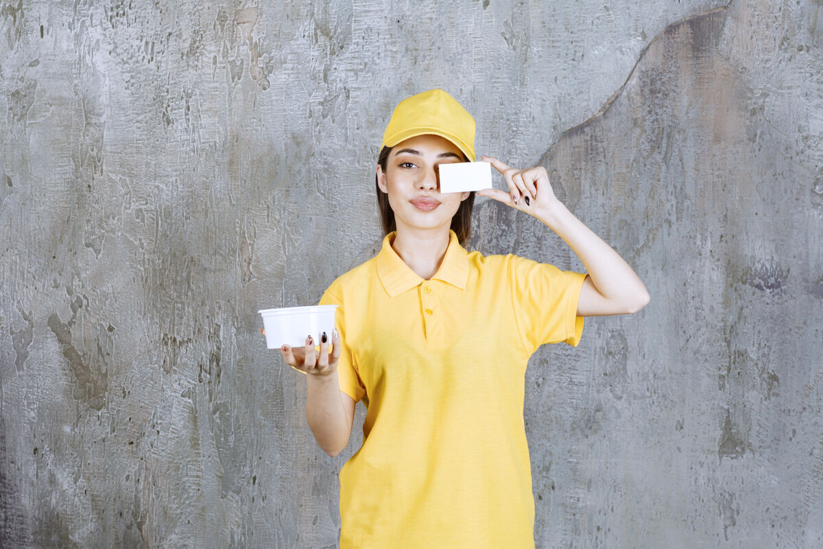 快递身着黄色制服的女服务人员手持塑料外卖碗 出示名片成人电子邮件女人
