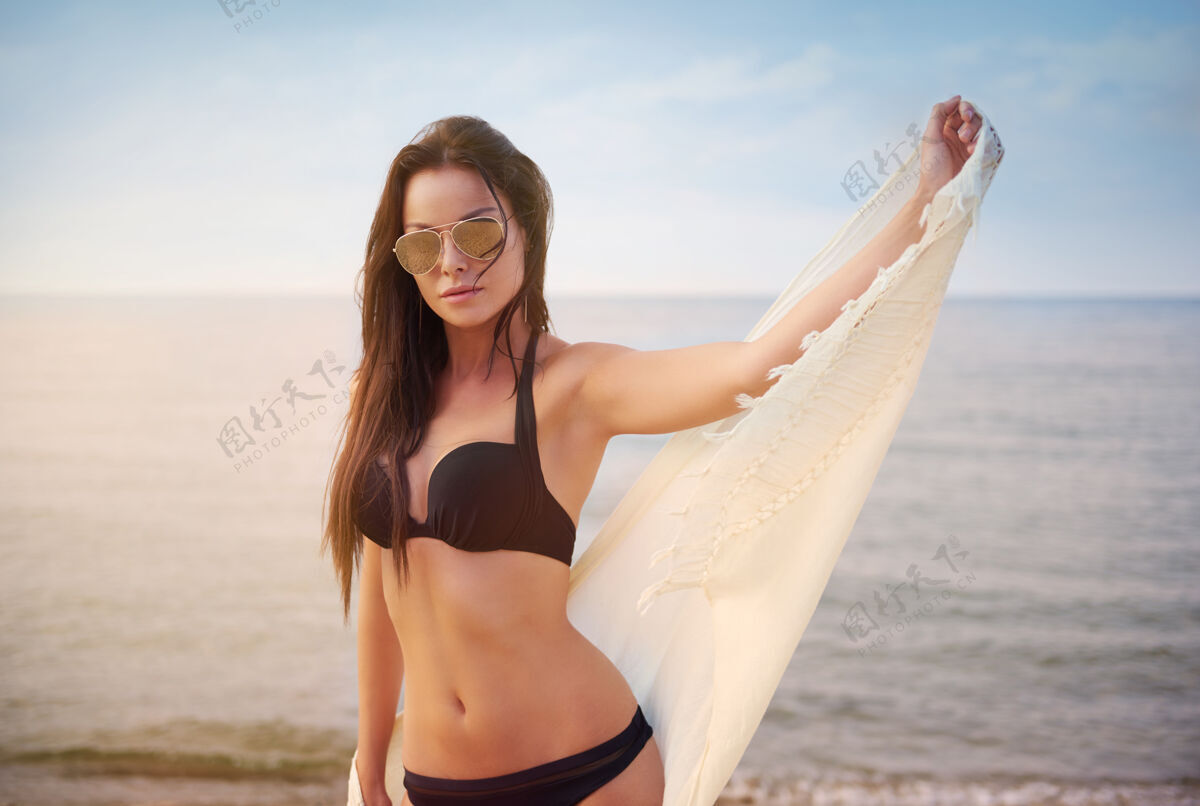 女人年轻漂亮的女人在沙滩上玩得很开心海边海滩漂亮