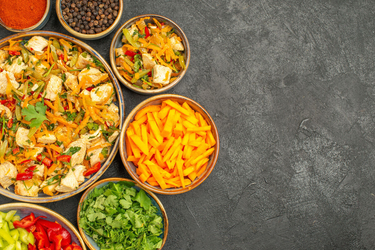 胡椒顶视图鸡肉沙拉与蔬菜和蔬菜对黑暗的餐桌饮食健康烹饪盘子食物