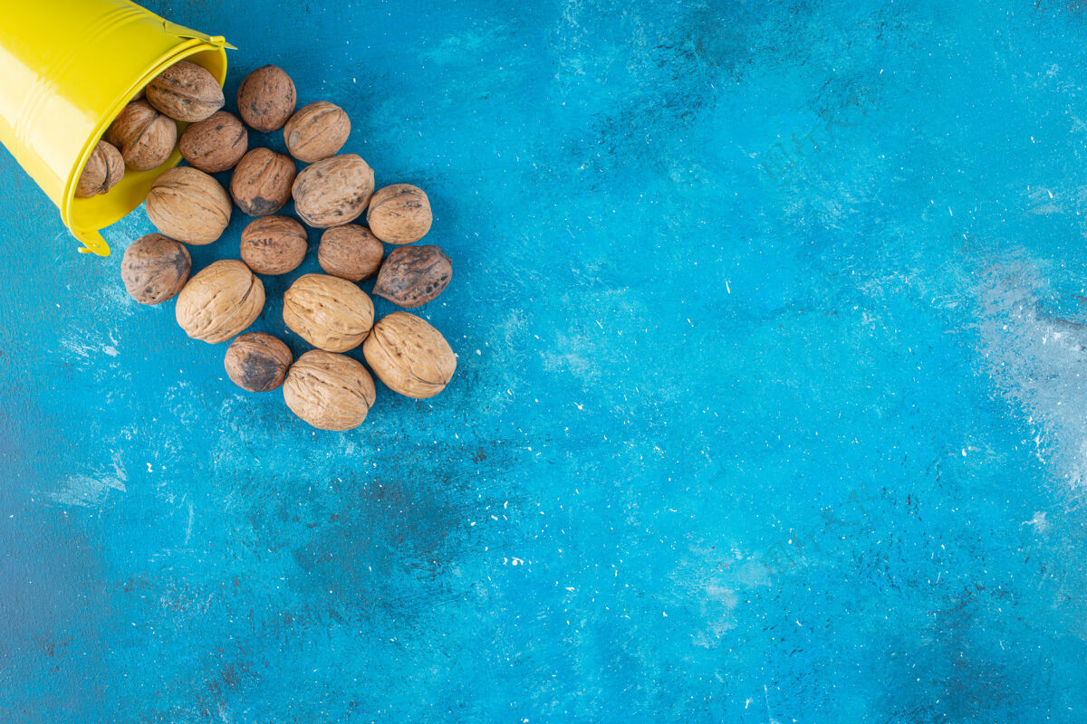 美味把核桃壳放在蓝色的桶里木桶美味健康