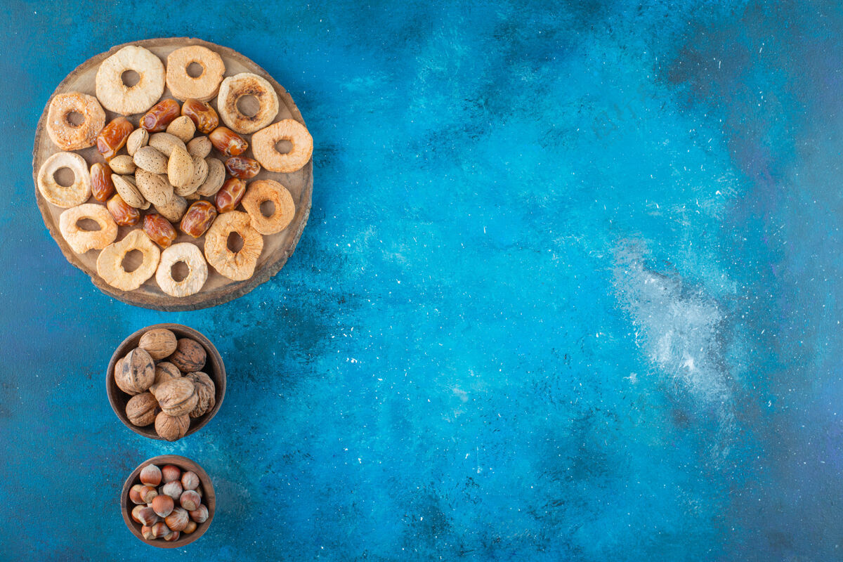 壳干果和美味的坚果放在蓝色的木板上坚果板杏仁