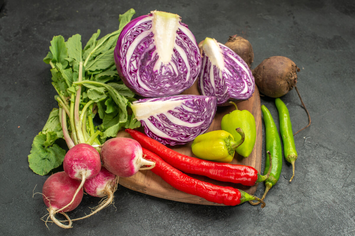 食物前视图新鲜的红色卷心菜搭配其他蔬菜上深色餐桌沙拉饮食健康成熟健康农产品新鲜的红白菜