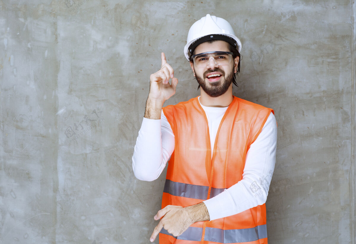 促销戴着白色头盔和防护眼镜的工程师上下指指点点人雇员方向