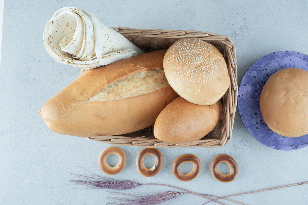 饼干篮子里的各种面包和石头表面的饼干小麦芝麻面包