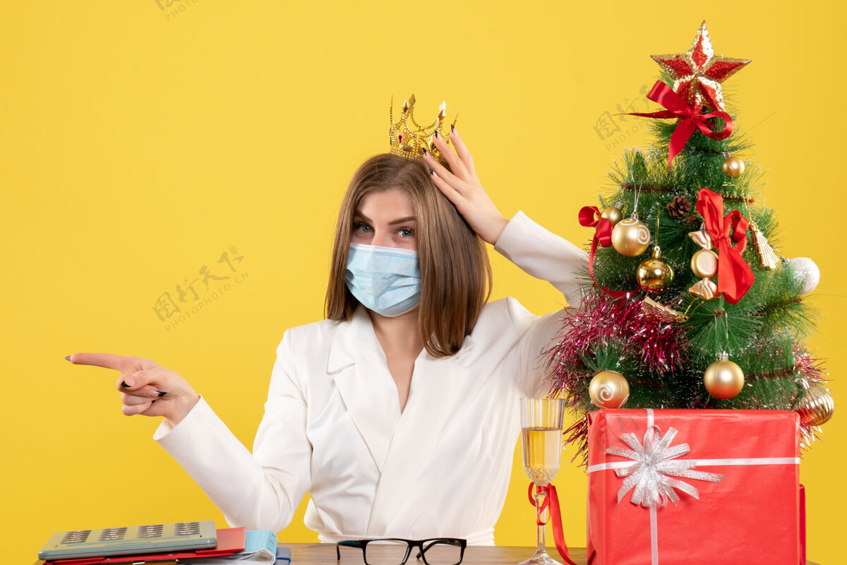 肖像正面图：戴着无菌面罩戴着皇冠的女医生成人圣诞节皇冠