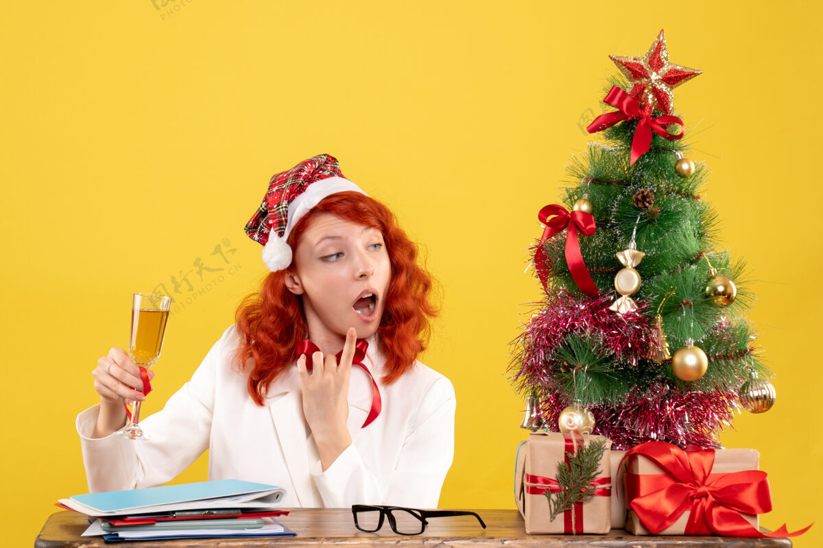成人正面图女医生坐着用香槟庆祝圣诞节美丽圣诞节微笑