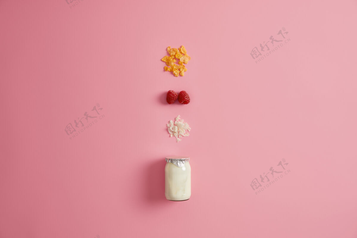 平板健康的超级食品和有机营养概念一罐新鲜酸奶和三种营养成分 用于准备早餐格兰诺拉麦片 红色覆盆子和椰子片 粉红色背景格兰诺拉麦片美食配料