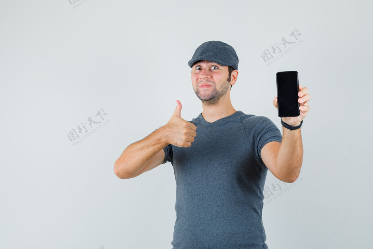 商务网络摄像头戴着t恤帽的年轻男子举着手机竖起大拇指远视小儿童