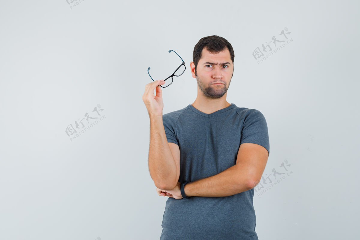 孩子身穿灰色t恤的年轻男子举着眼镜 神情犹豫不决男孩商务摄像头电脑摄像头