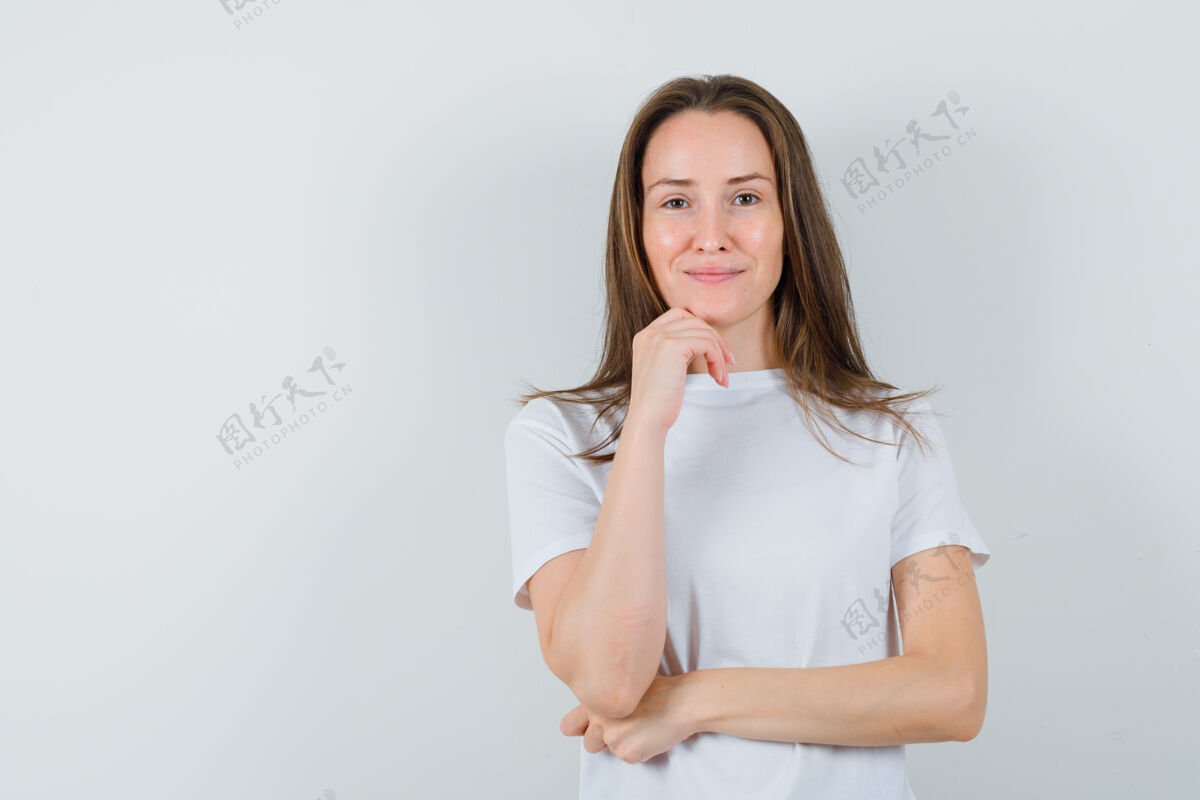 休闲穿着白色t恤的年轻女士站在思考的姿势 看起来很理智时尚敏感优雅