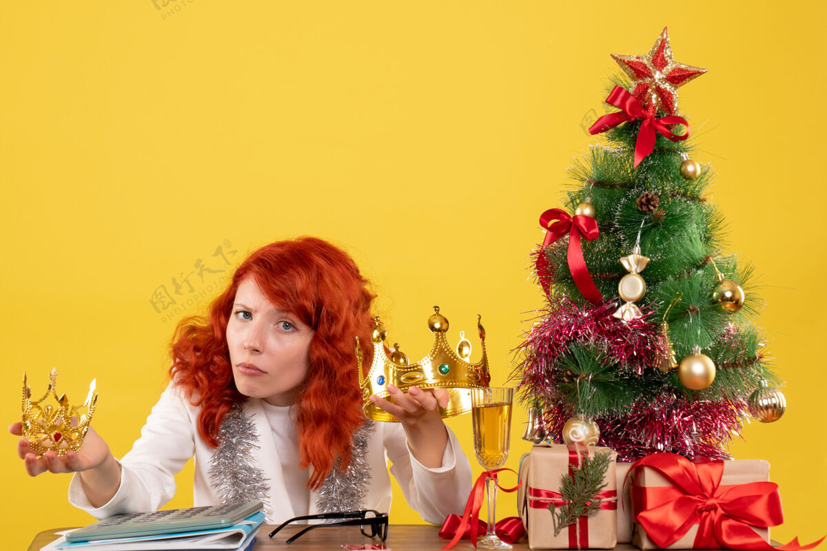 插花前视图女医生手持圣诞树周围的皇冠和礼物美丽颜色周围