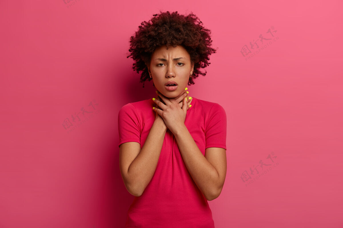 窒息不高兴的黑皮肤女人有哮喘发作 呼吸不好 手放在脖子上 皱眉头 窒息或窒息 咳嗽 有健康问题 穿着休闲服 隔离在粉红色室内自杀阴性