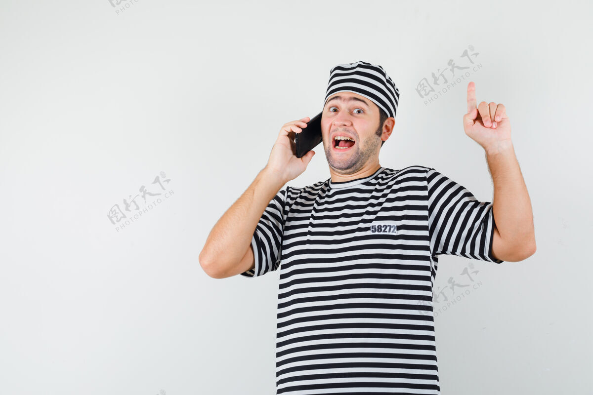 帽子男青年穿着t恤 戴着帽子讲着手机 指着头看着开心 眼前一亮人站立男人