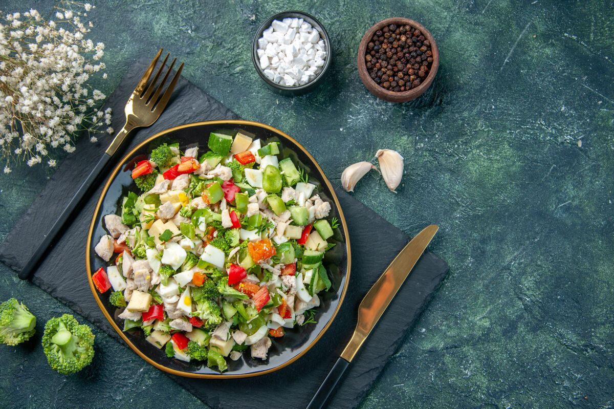 正餐顶视图美味的蔬菜沙拉在深蓝色背景的盘子里烹饪餐厅新鲜的一餐颜色健康的午餐食物饮食沙拉晚餐新鲜