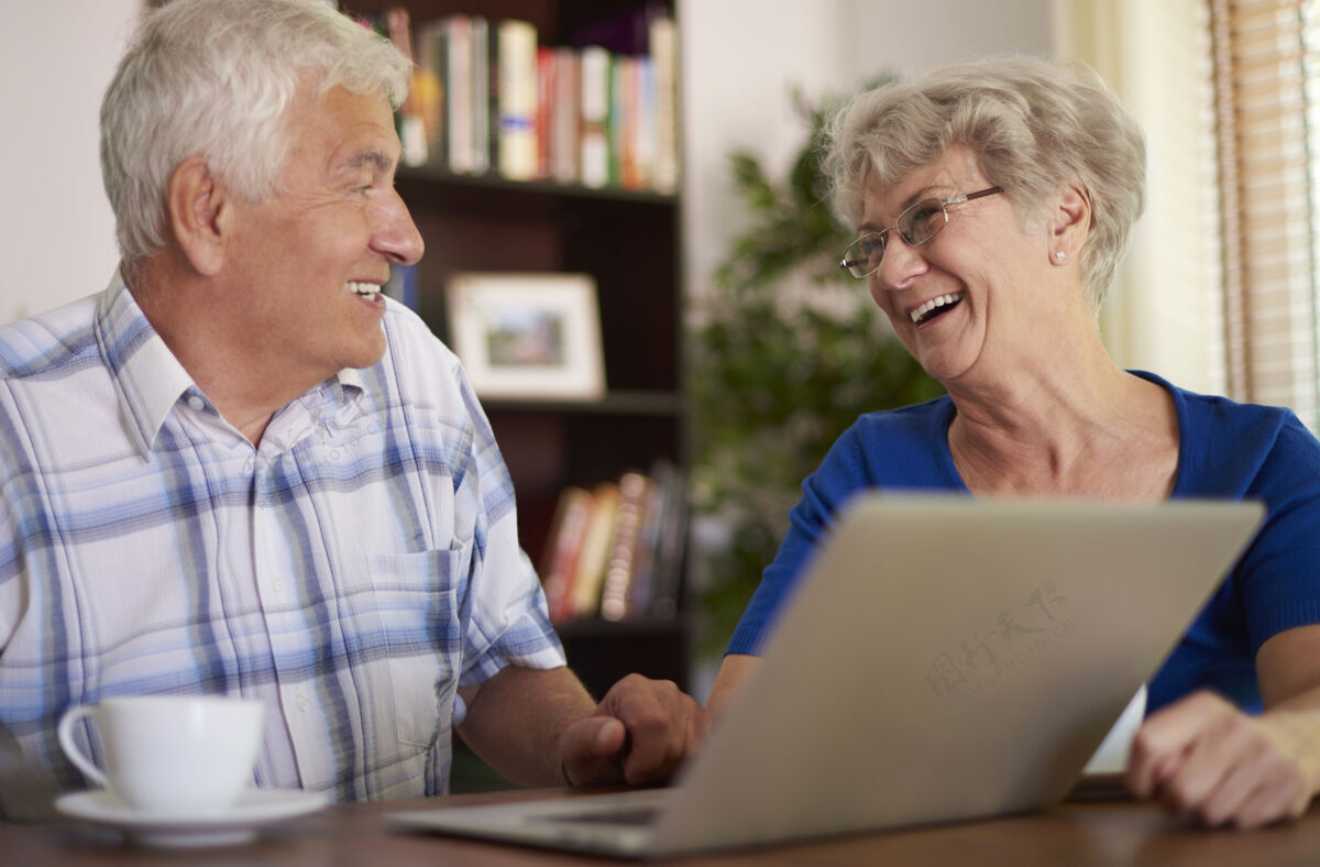 网络快乐的老年夫妇使用他们的笔记本电脑老年夫妇活力女人