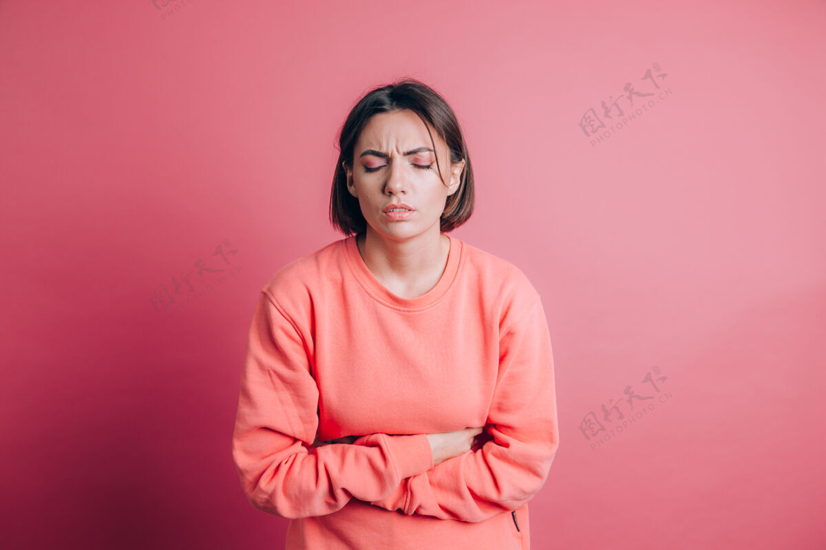 女性女人穿着休闲毛衣就背着肚子疼带着痛苦的鬼脸 感觉突然的经期抽筋 妇科概念复制空间快乐疼痛