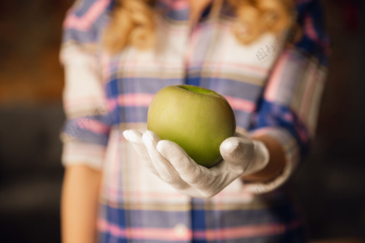 皮肤特写镜头中戴着手套的女性手拿着青苹果 健康食品 水果水果人类女人