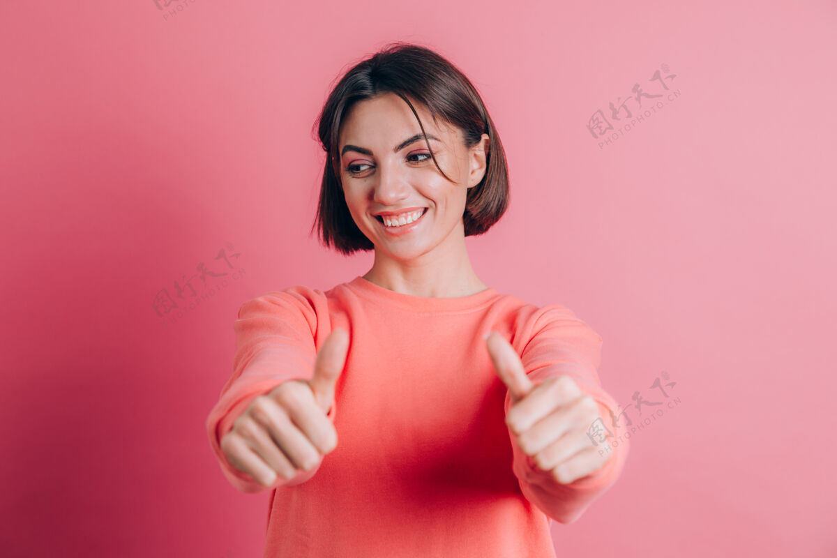 人背景上穿着休闲毛衣的女人用手做着积极的手势 微笑着竖起大拇指 为成功而高兴华丽喜悦微笑