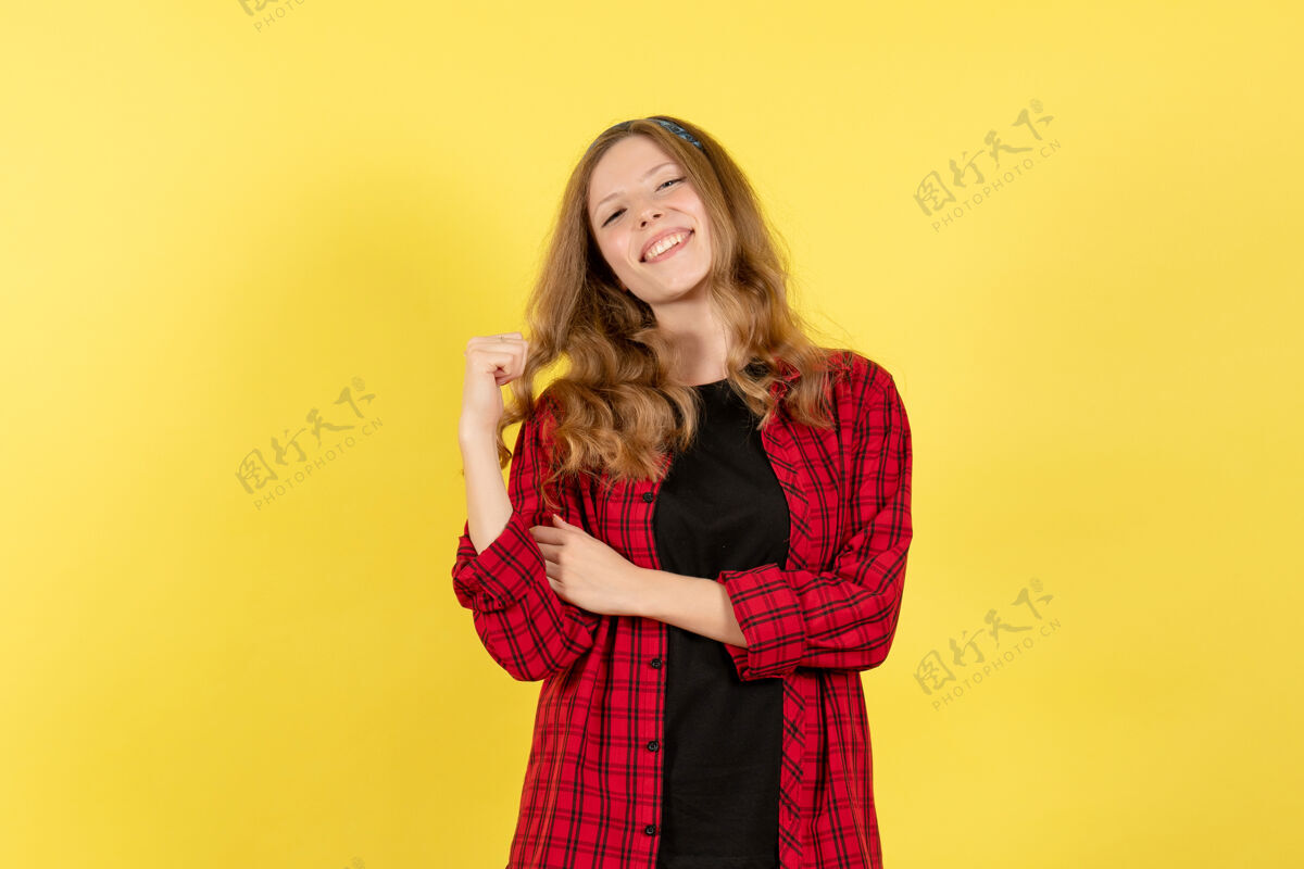 漂亮正面图身着红色格子衬衫的年轻女性站在黄色背景上微笑的女孩人类女性彩色模型年轻女性女孩衬衫
