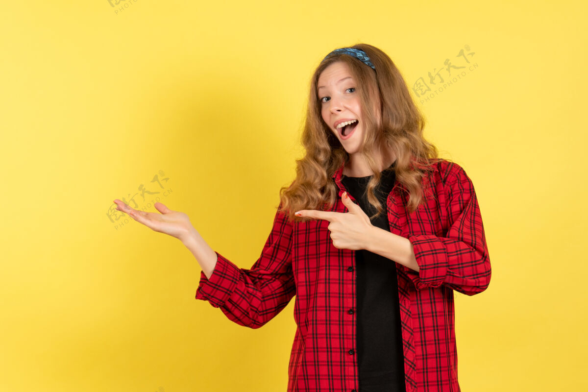 漂亮正面图穿着红色格子衬衫的年轻女性站在黄色背景色的模特儿上摆姿势微笑肖像格子