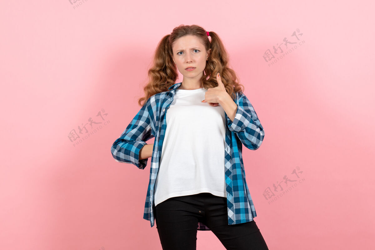 漂亮正面图：穿着格子衬衫的年轻女性在粉色背景上摆姿势模特情感儿童青年女女孩孩子头发年轻