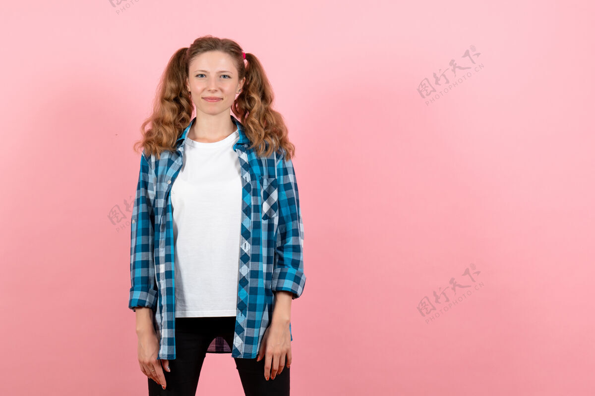 漂亮正面图身着蓝色格子衬衫的年轻女性在粉色背景上摆姿势女性情感女孩时尚色彩模特衣服格子女孩