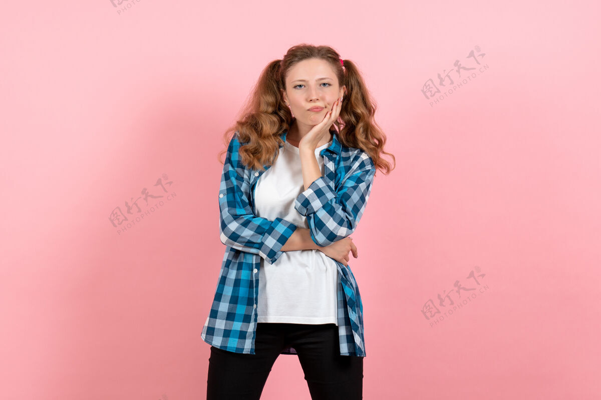 年轻女性正面图身着格子衬衫的年轻女性在粉色背景上摆姿势年轻女性彩色情感模特儿成人微笑年轻